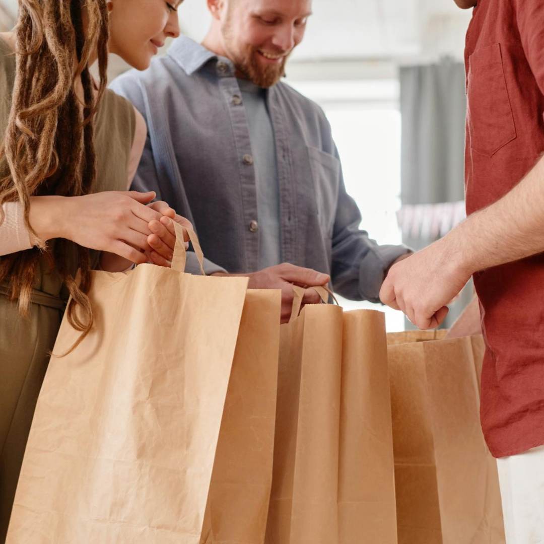 A lady and man holding brown paper bags