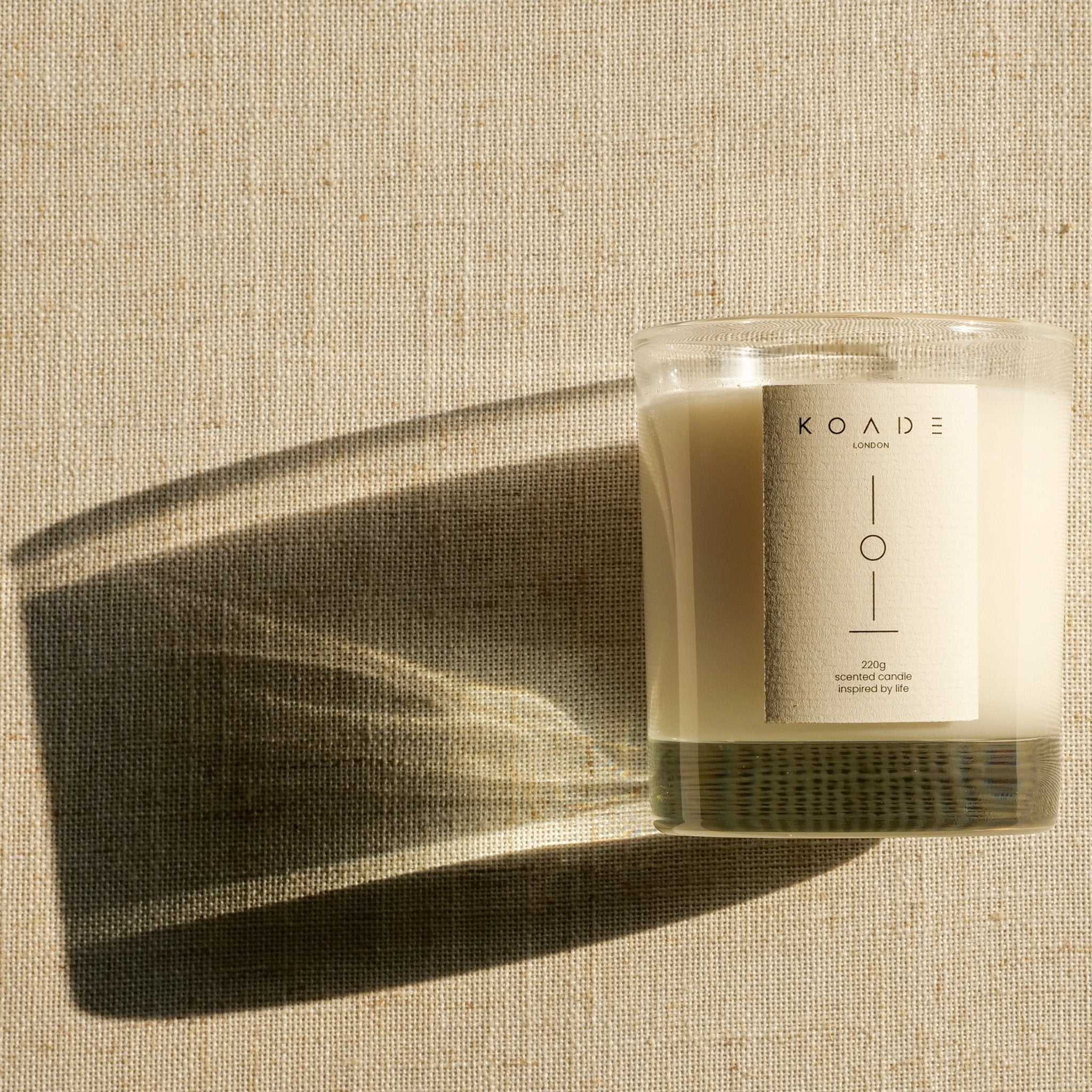 Candle with a label on a textured beige background