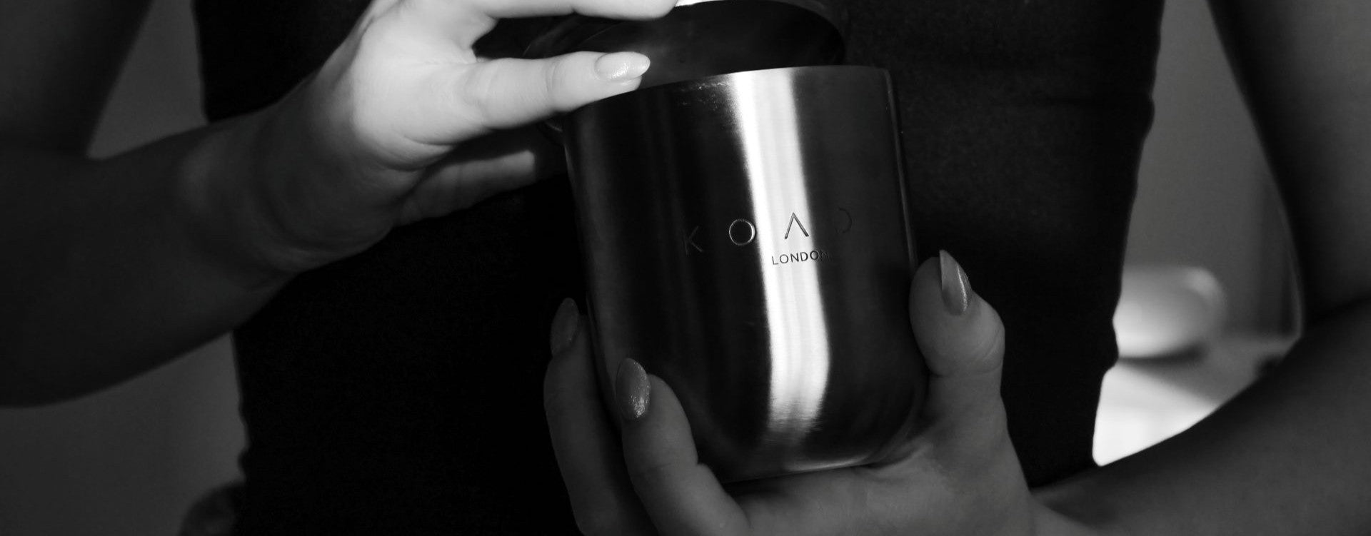Person holding a metallic cup with 'KOADE London' branding.