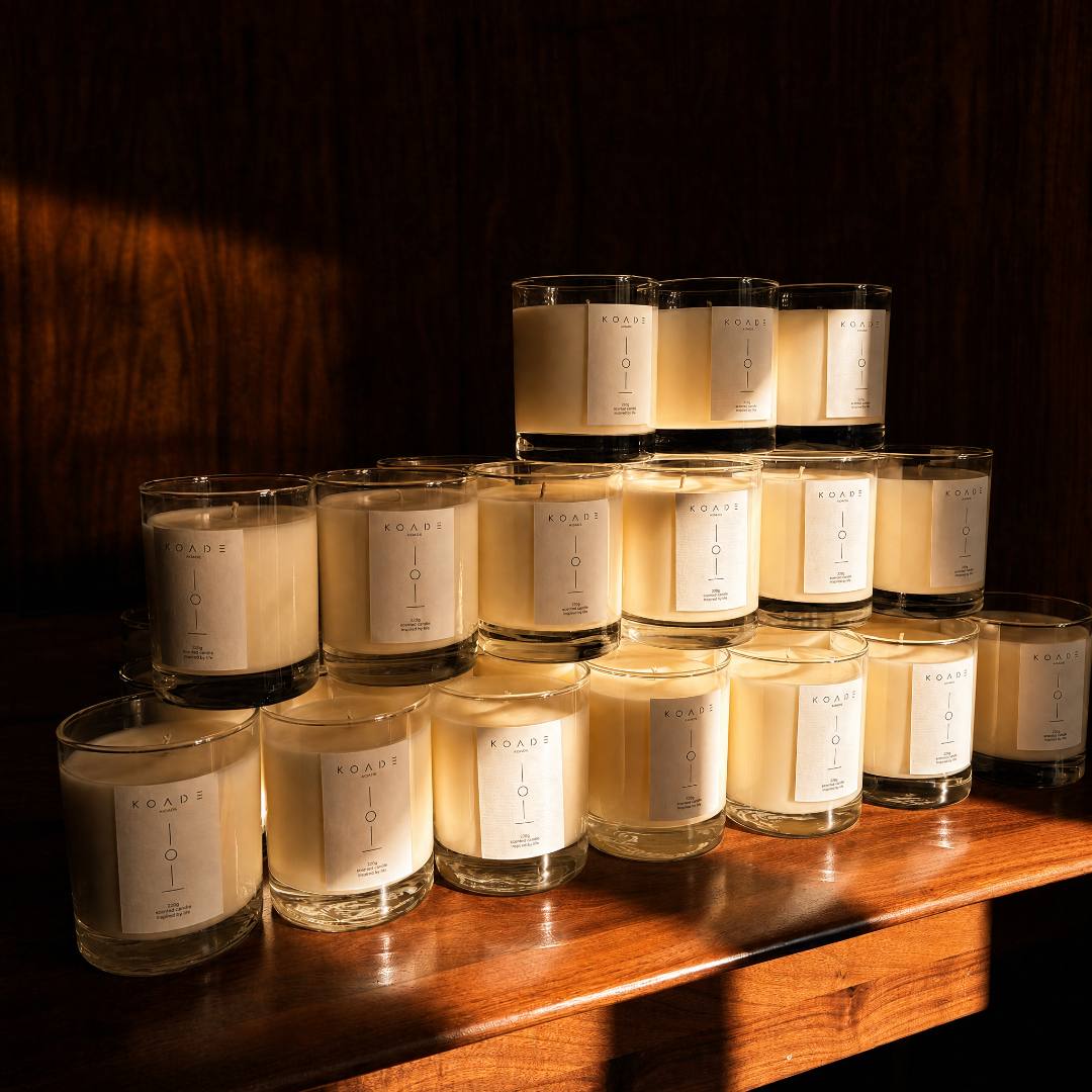 Row of candles with labels on a wooden surface against a dark background