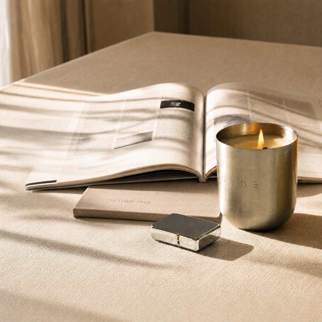 Candle in Metal Container next to a book