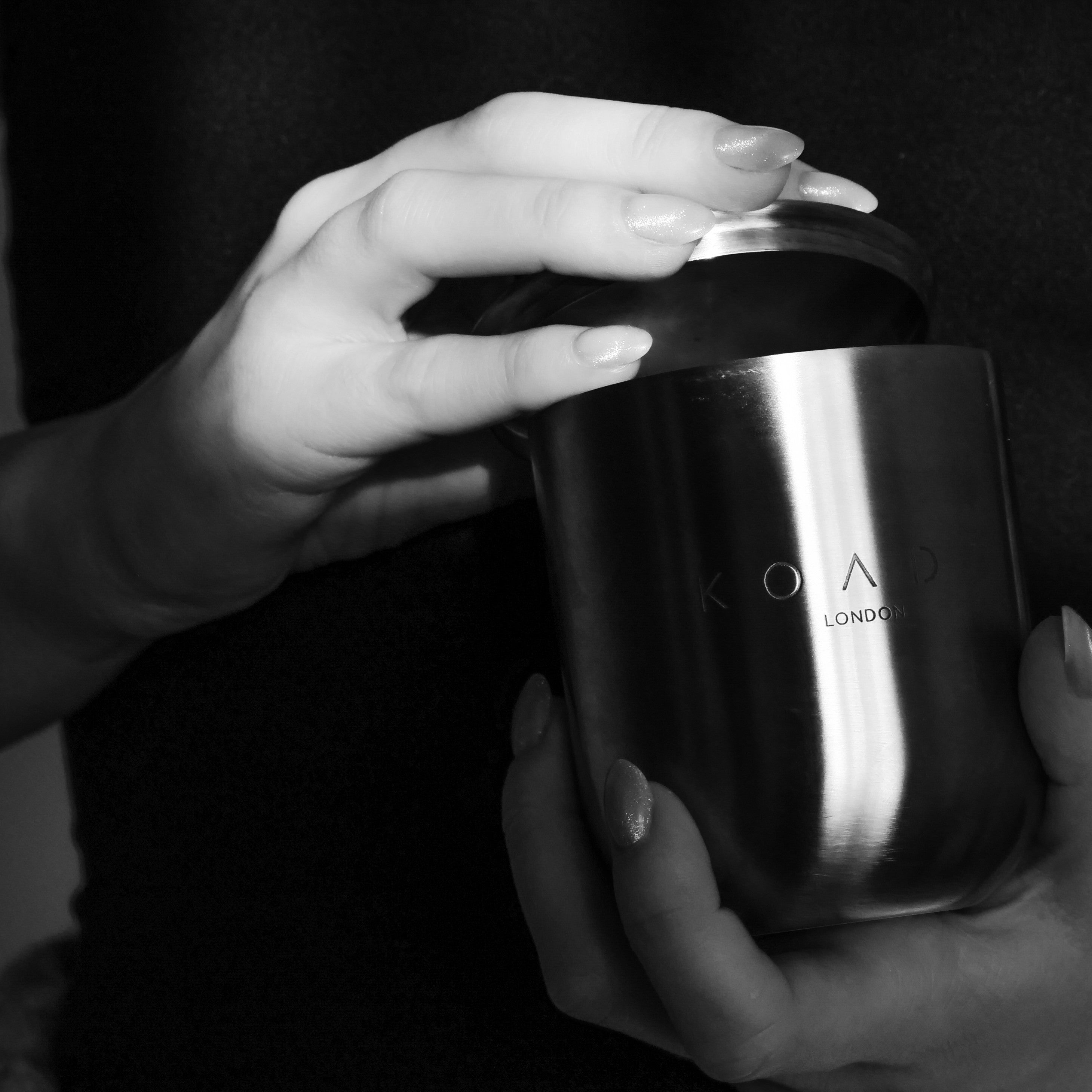Person holding a metallic container with 'KOADE London' branding