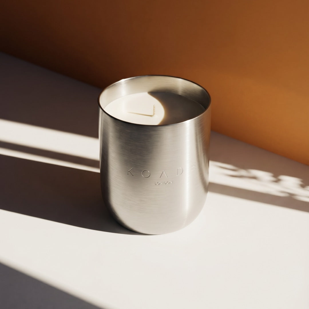 Silver candle holder with KOADE branding on a neutral background