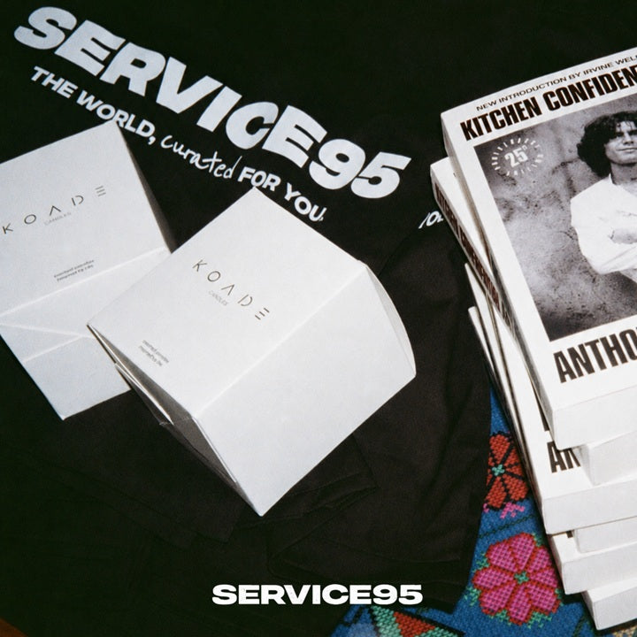 White boxes with 'SERVICE95' branding on a black surface with a magazine titled 'KITCHEN CONFIDENCE'.
