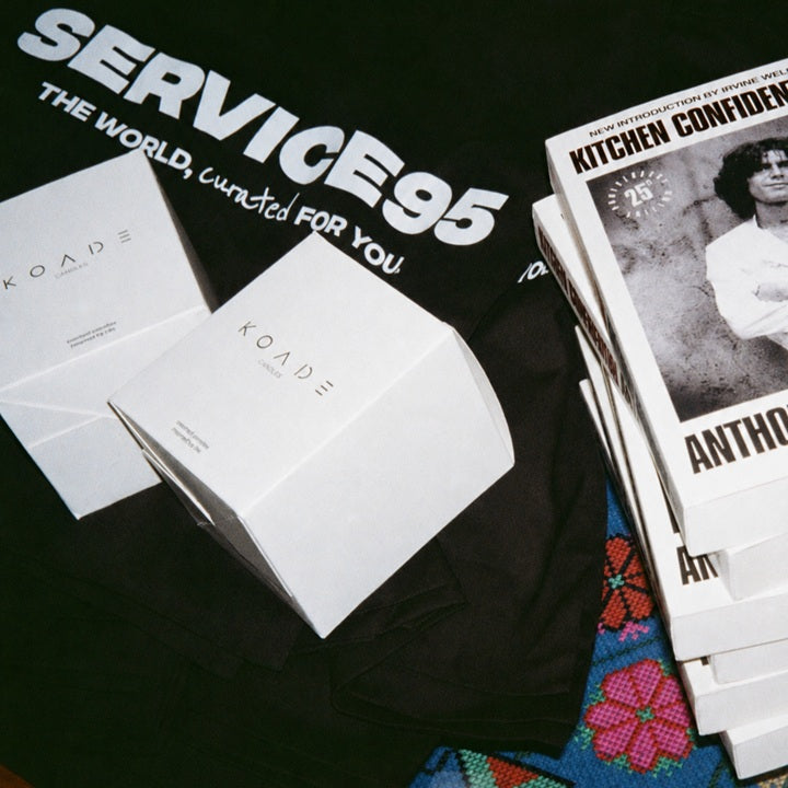 White box with 'Koade' branding on a black surface with promotional materials.