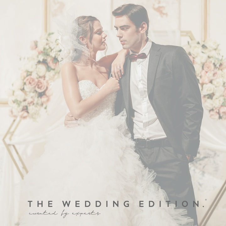 Wedding couple embracing with floral decorations in the background
